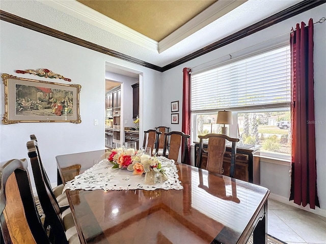 dining area featuring crown molding, a raised ceiling, and light tile patterned floors