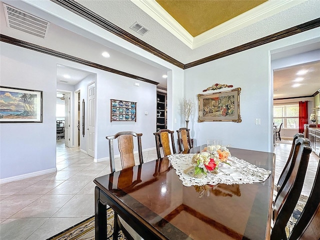 tiled dining room with crown molding, a raised ceiling, and a textured ceiling