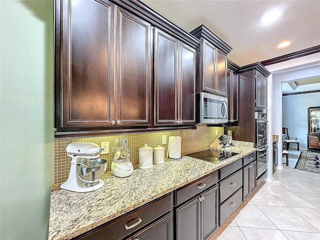 kitchen with tasteful backsplash, light tile patterned floors, dark brown cabinetry, stainless steel appliances, and light stone countertops