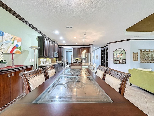 tiled dining area with crown molding and a textured ceiling