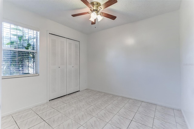 unfurnished bedroom with ceiling fan, a closet, and a textured ceiling