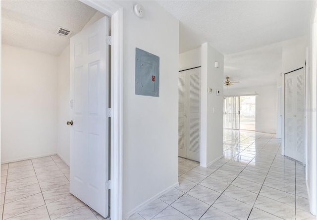 hall featuring electric panel and a textured ceiling