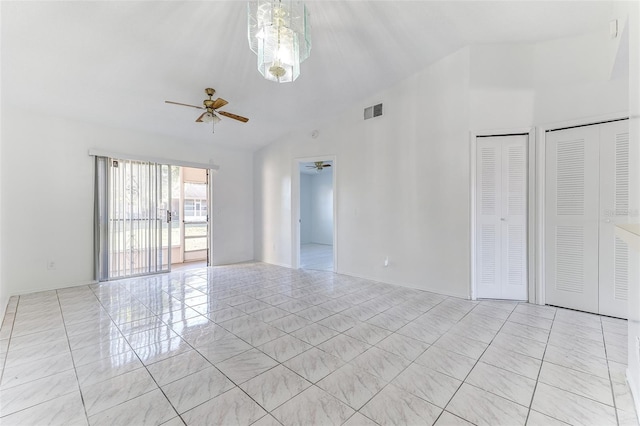 empty room with lofted ceiling, light tile patterned floors, and ceiling fan