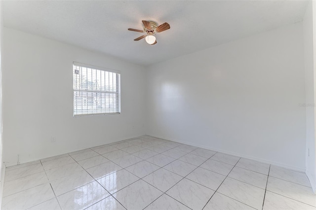 tiled spare room with ceiling fan