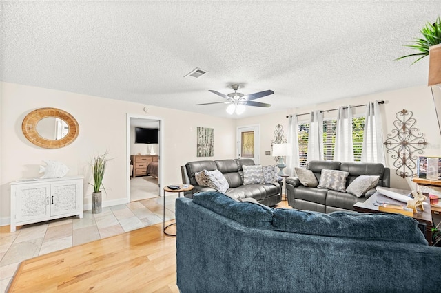 living room with ceiling fan, hardwood / wood-style floors, and a textured ceiling