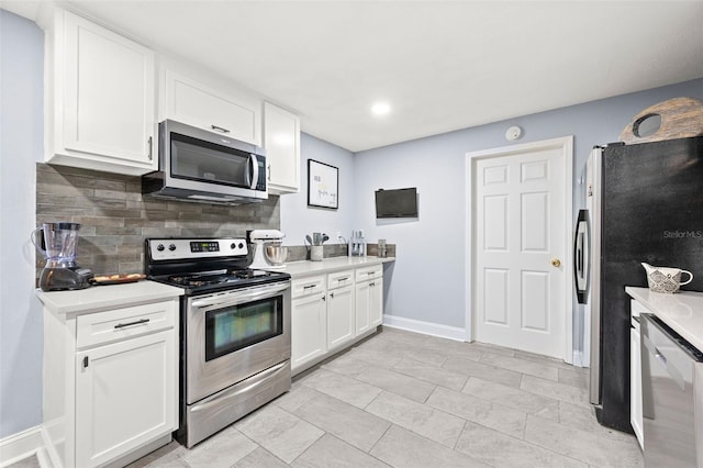 kitchen with backsplash, stainless steel appliances, and white cabinets