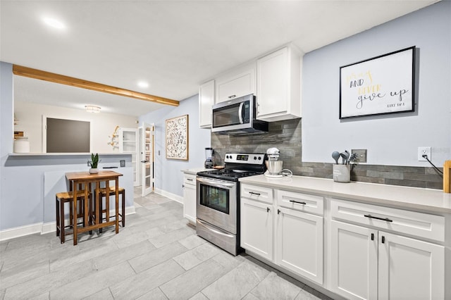 kitchen with white cabinetry, tasteful backsplash, and stainless steel appliances