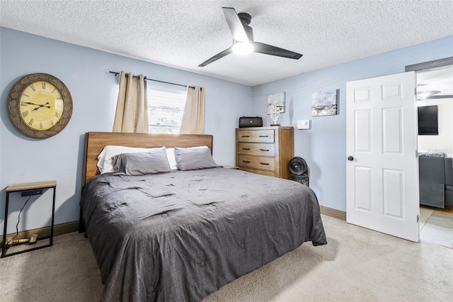 carpeted bedroom with ceiling fan and a textured ceiling