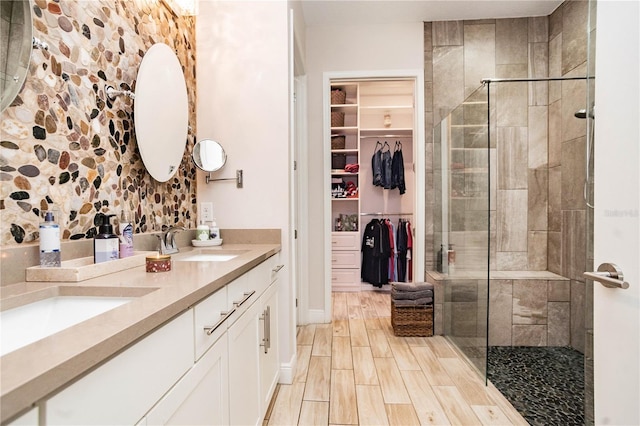 bathroom with tiled shower and vanity