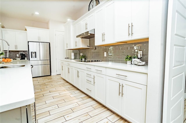 kitchen with stainless steel refrigerator with ice dispenser, black electric cooktop, light hardwood / wood-style floors, and white cabinets