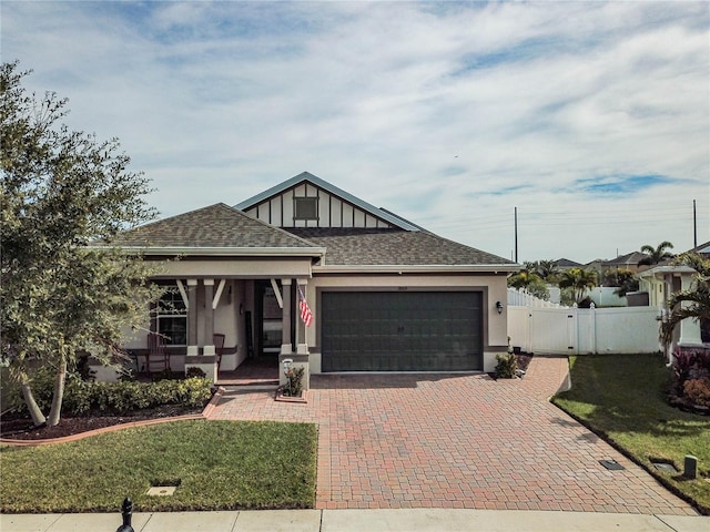 view of front of house with a garage, a front yard, and covered porch