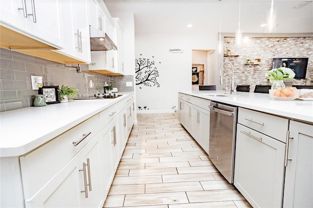 kitchen with tasteful backsplash, dishwasher, sink, white cabinets, and hanging light fixtures