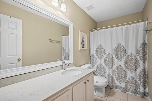 bathroom featuring vanity, toilet, tile patterned flooring, and a textured ceiling