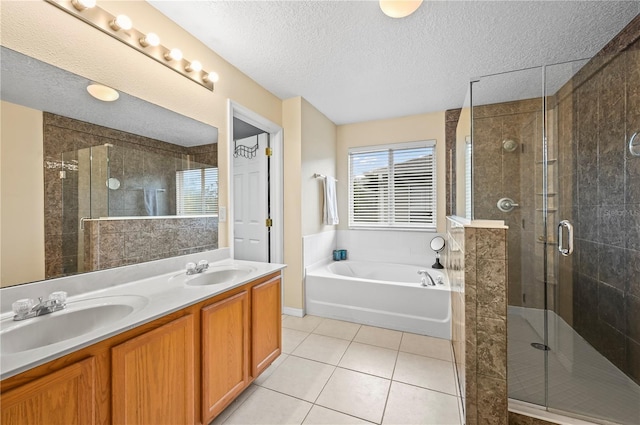 bathroom with tile patterned flooring, vanity, plus walk in shower, and a textured ceiling