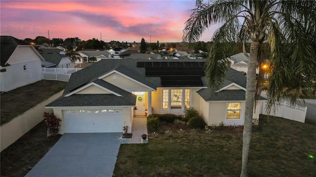 view of front of property featuring a garage and a lawn