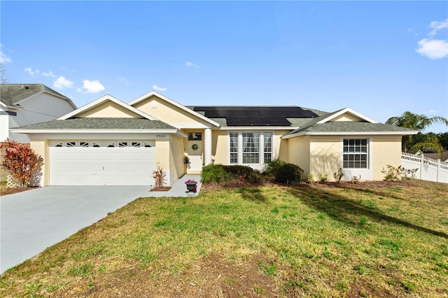 ranch-style home with a garage, a front yard, and solar panels