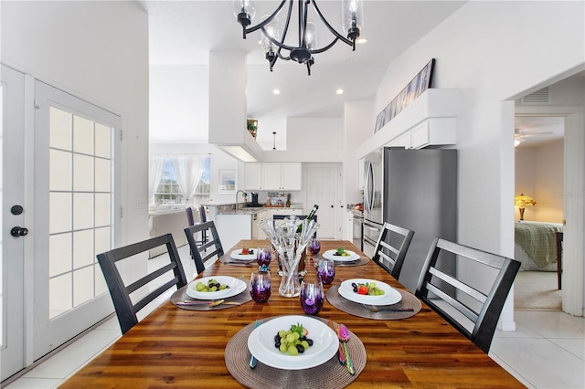 dining room featuring an inviting chandelier, light tile patterned floors, a towering ceiling, and sink