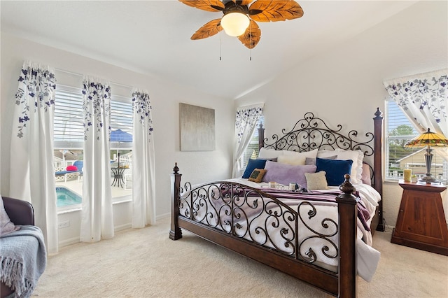 bedroom featuring ceiling fan, light colored carpet, vaulted ceiling, and multiple windows