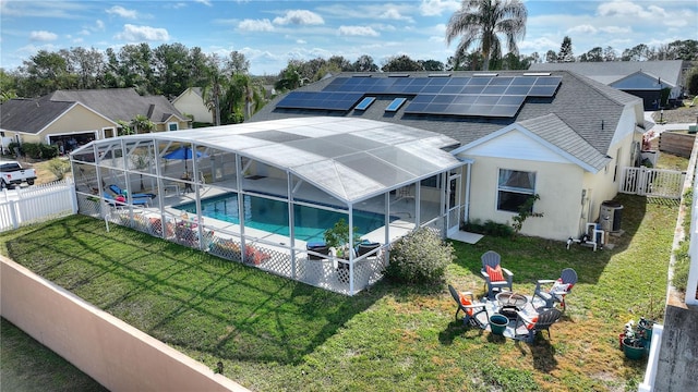 view of pool with a lanai, a yard, a patio, an outdoor fire pit, and central AC unit