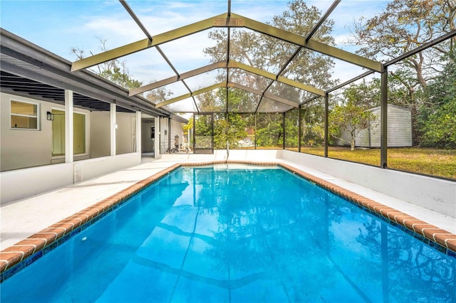 view of swimming pool with a storage unit, a lanai, and a patio area