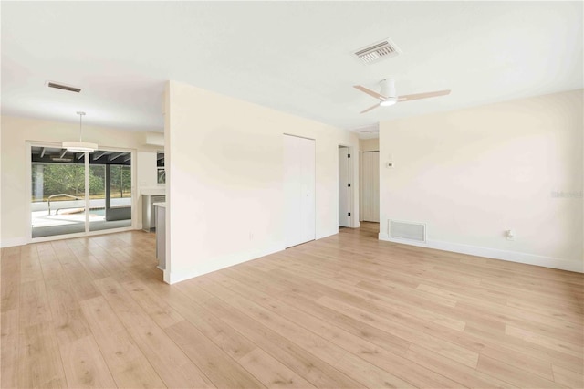 empty room with ceiling fan and light hardwood / wood-style flooring