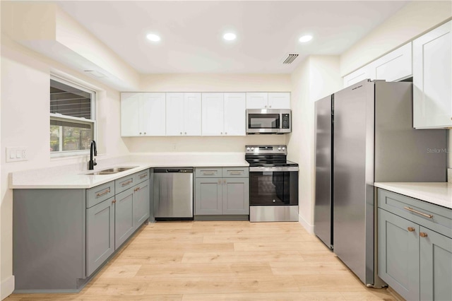 kitchen with gray cabinets, appliances with stainless steel finishes, and sink