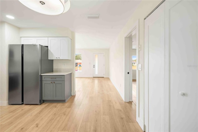 kitchen featuring light hardwood / wood-style flooring, white cabinetry, gray cabinets, and stainless steel refrigerator