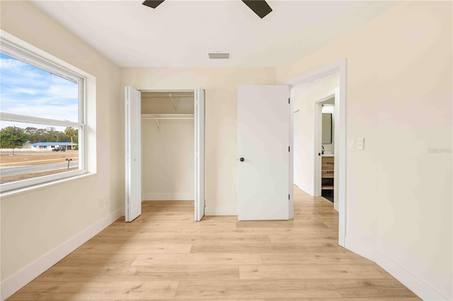 unfurnished bedroom with light hardwood / wood-style flooring, a closet, and ceiling fan