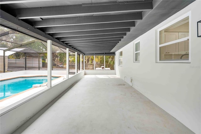 view of swimming pool featuring glass enclosure and a patio