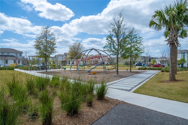 communal playground featuring a lawn and a residential view