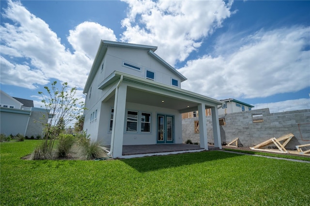 back of property with a patio, a lawn, fence, and stucco siding