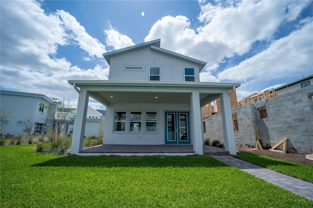 back of house featuring a yard, fence, and stucco siding