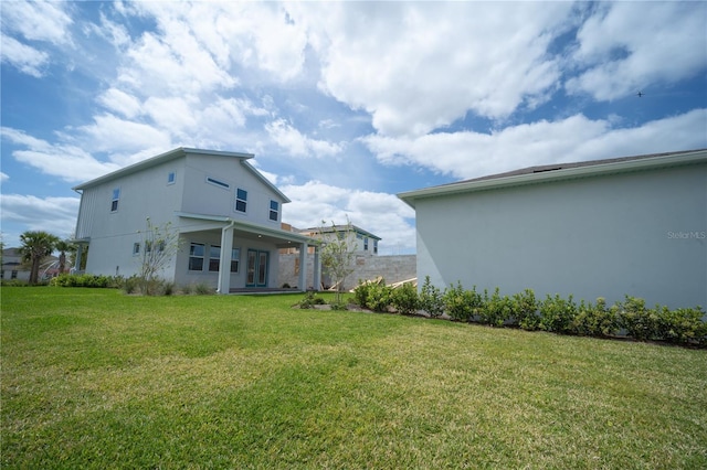 back of house featuring a yard and stucco siding