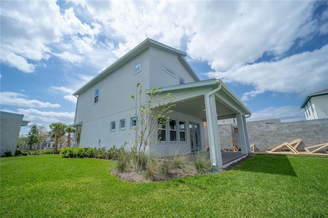 view of home's exterior with a lawn and stucco siding