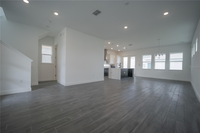 unfurnished living room with visible vents, baseboards, a chandelier, recessed lighting, and dark wood-style flooring