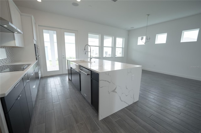 kitchen featuring black electric cooktop, stainless steel dishwasher, a healthy amount of sunlight, and dark wood-style flooring