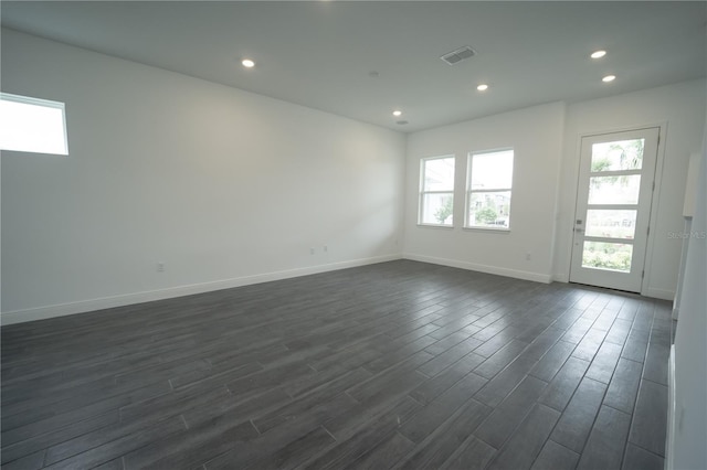 unfurnished room with recessed lighting, visible vents, baseboards, and dark wood-style floors