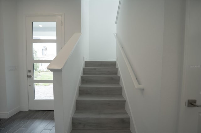 stairway featuring baseboards and wood finished floors