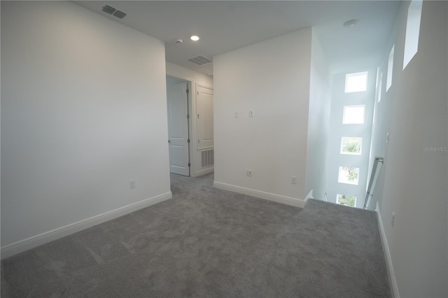 empty room with visible vents, carpet flooring, and baseboards