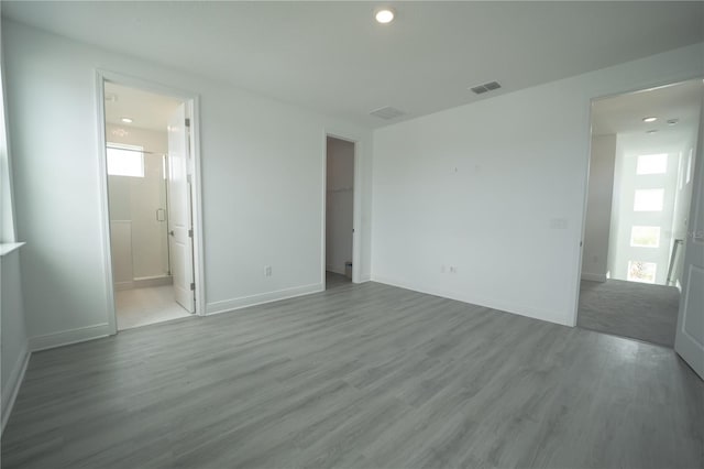 spare room with visible vents, baseboards, and wood finished floors