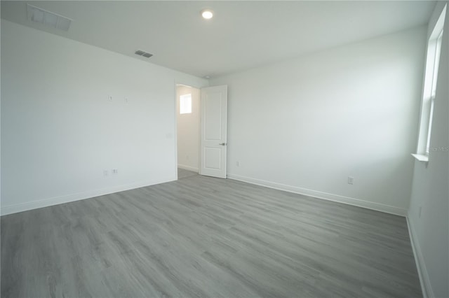 unfurnished room featuring wood finished floors, baseboards, and visible vents