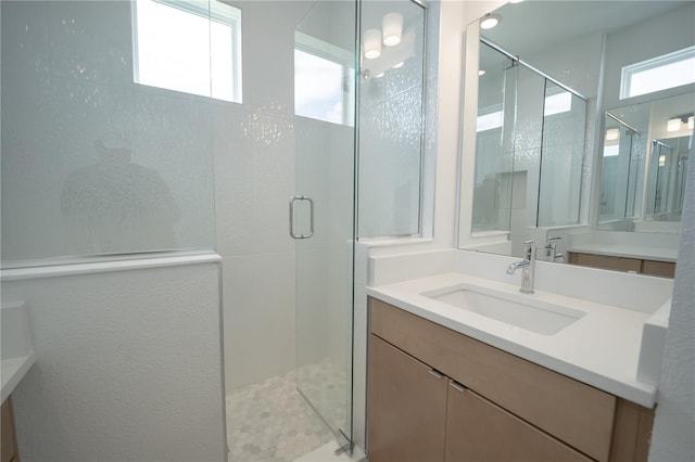 bathroom with a shower stall and vanity