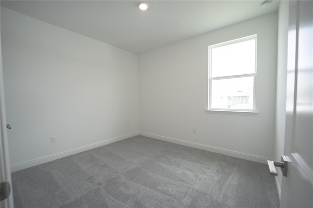 unfurnished room with baseboards and carpet