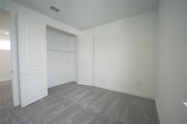 unfurnished bedroom featuring a closet, baseboards, visible vents, and carpet floors