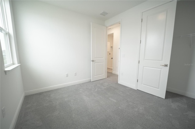 unfurnished bedroom featuring visible vents, carpet, and baseboards