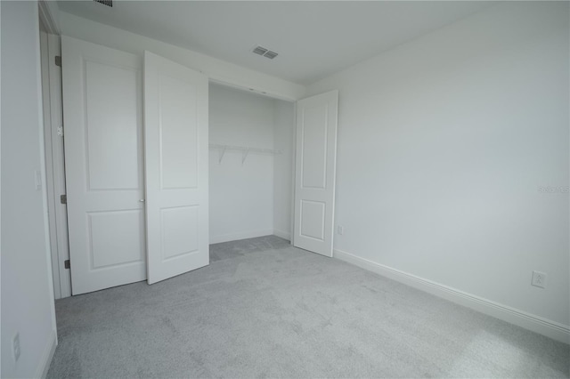 unfurnished bedroom featuring carpet, visible vents, a closet, and baseboards