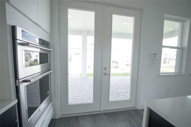 doorway with a healthy amount of sunlight, french doors, and wood finish floors