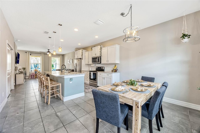 tiled dining room with sink and ceiling fan