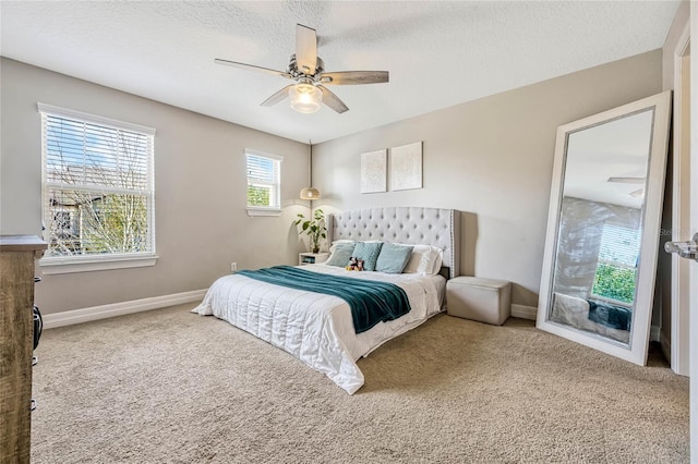 carpeted bedroom with ceiling fan and a textured ceiling