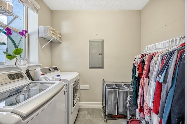 laundry room featuring laundry area, electric panel, baseboards, and washer and clothes dryer